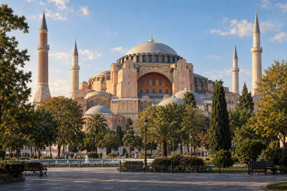 Hagia Sophia in Istanbul from the park, its great dome and buttresses with four minarets, visitors small on the paving, pale clear morning light