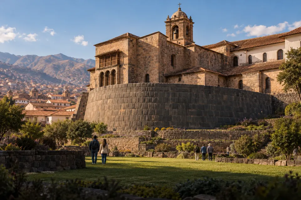 The Coricancha in Cuzco, the curved Inca ashlar wall of the Sun Temple supporting the church of Santo Domingo, visitors on the lawn, clear high-altitude morning light