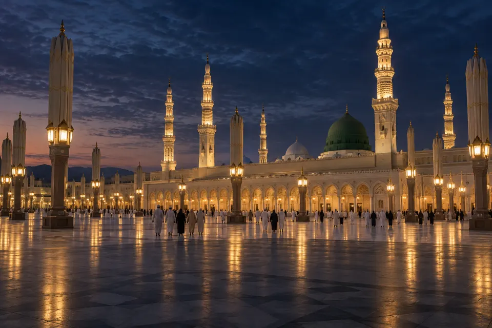 The green dome and minarets of the Prophet's Mosque, Medina, lit before dawn, pilgrims small on the plaza, deep blue sky with lamps along the arcades
